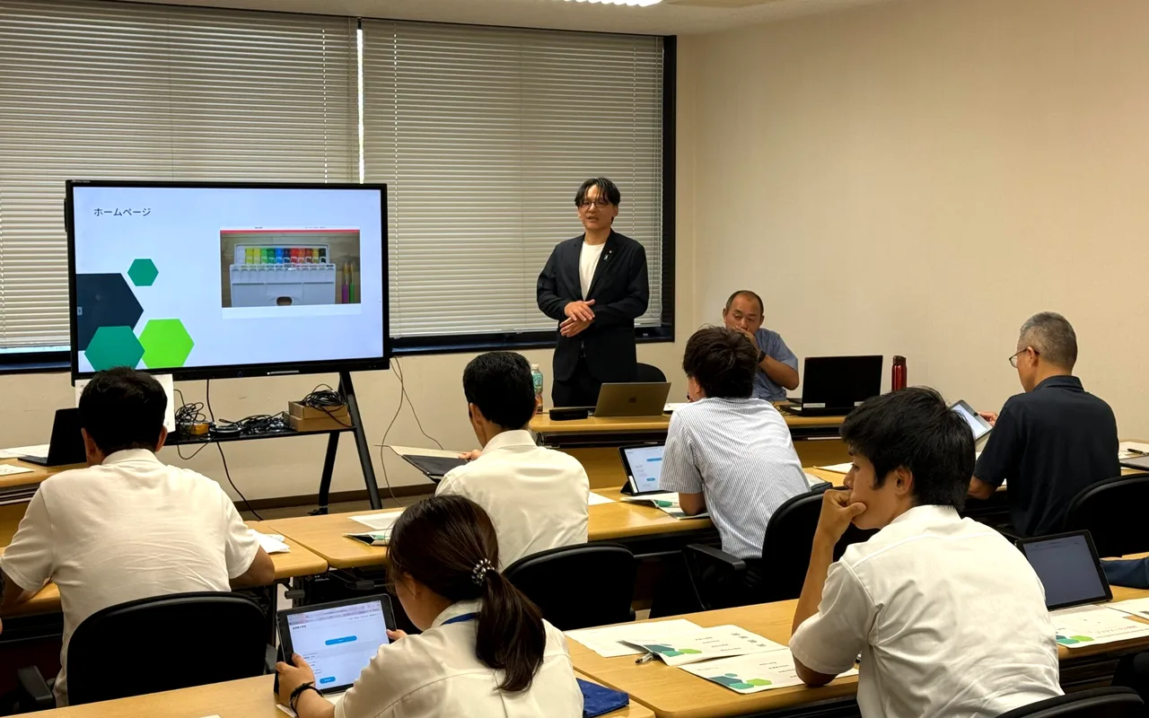 スクリーンを使って説明する青柳あつしと研修会の参加者
