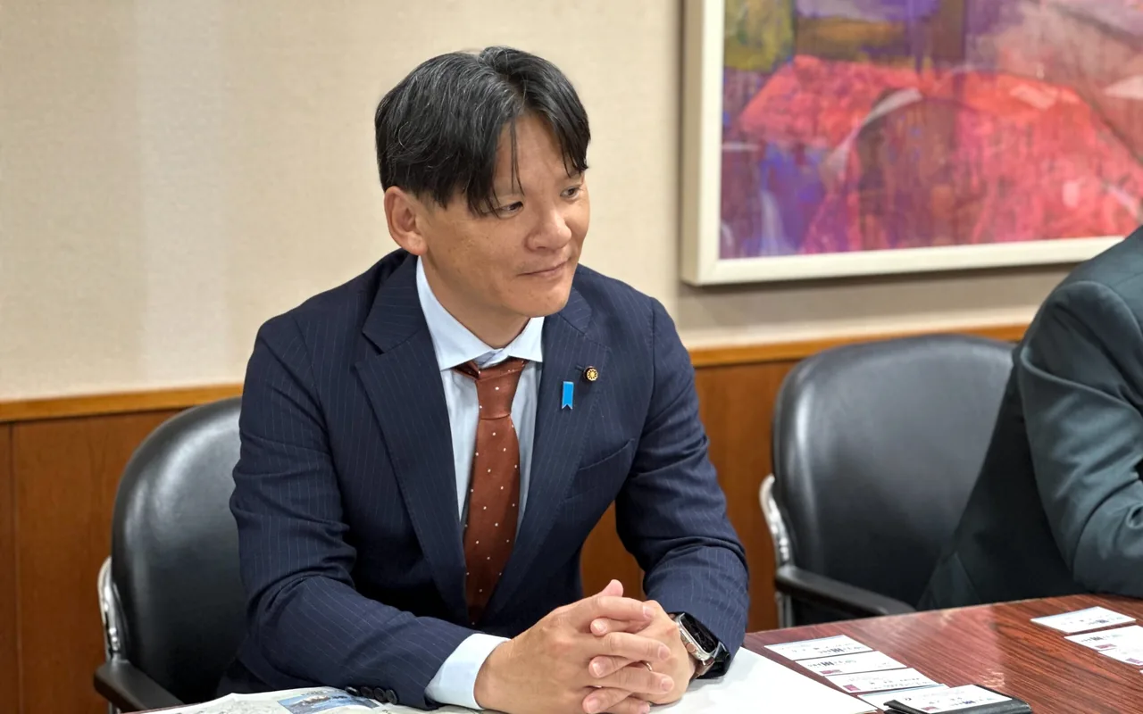 資料を前に相手の話を聞く青柳あつし