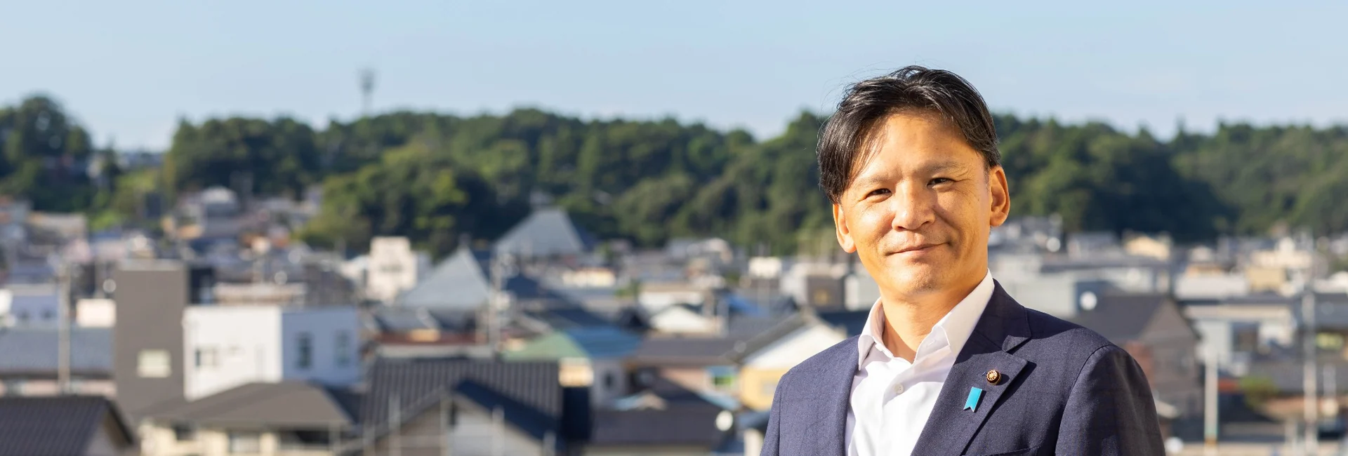 あわら市の街並みを背景に立つ青柳あつし